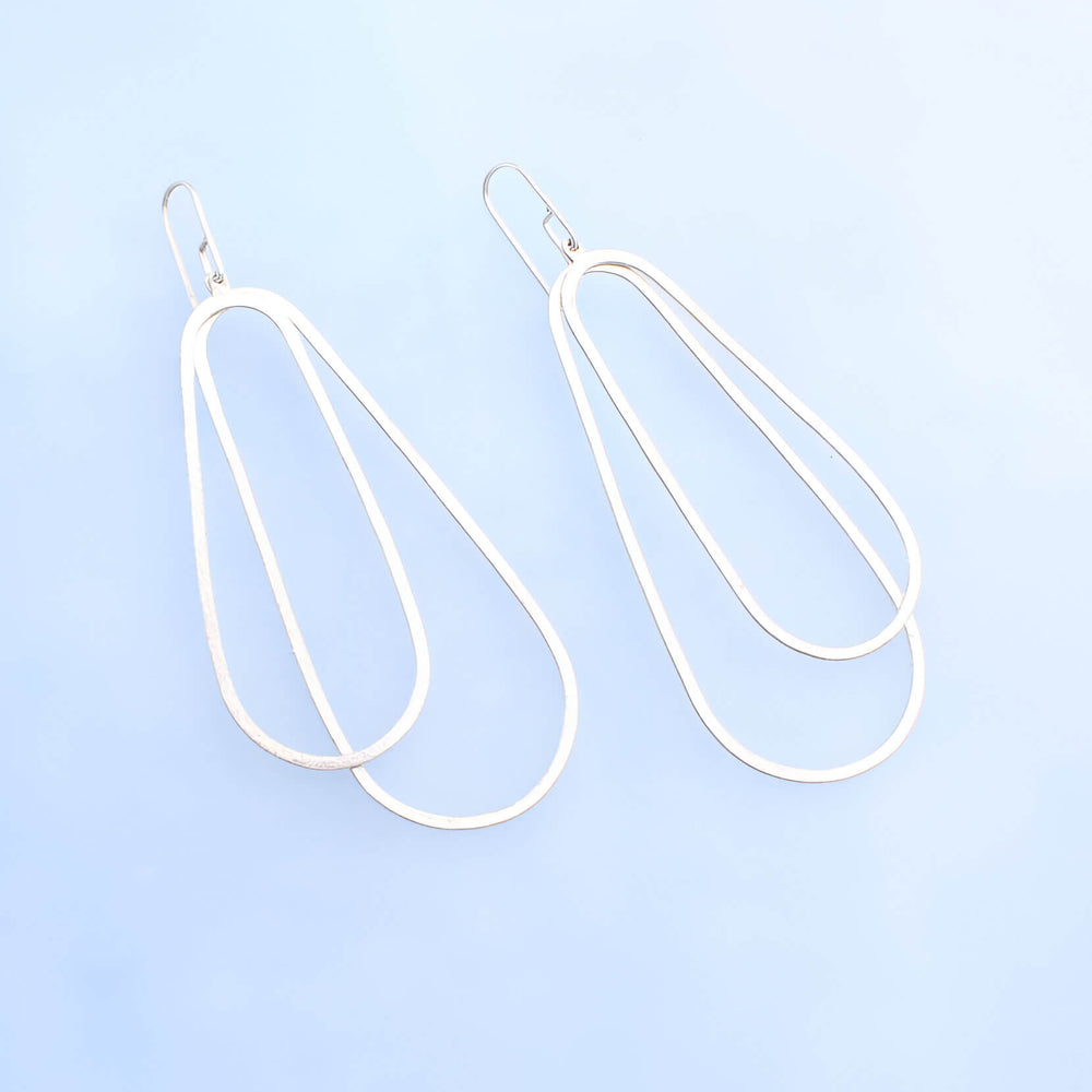 Long silver oval earrings with two silver ovoid's with silver ear wires. 3.5 inches long