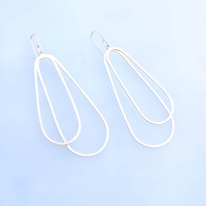 Long silver oval earrings with two silver ovoid's with silver ear wires. 3.5 inches long