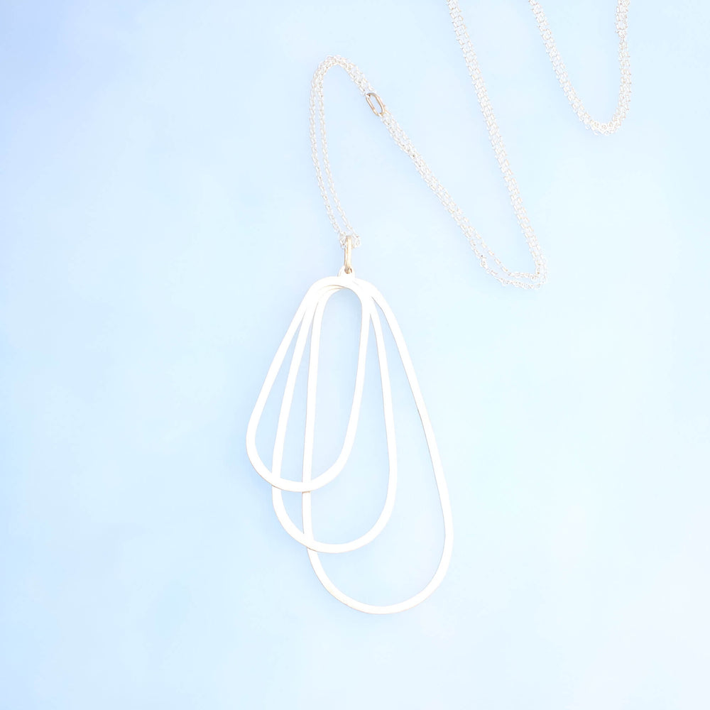 Silver pendant of three layered ovals and a silver rolo chian with 14k gold accents