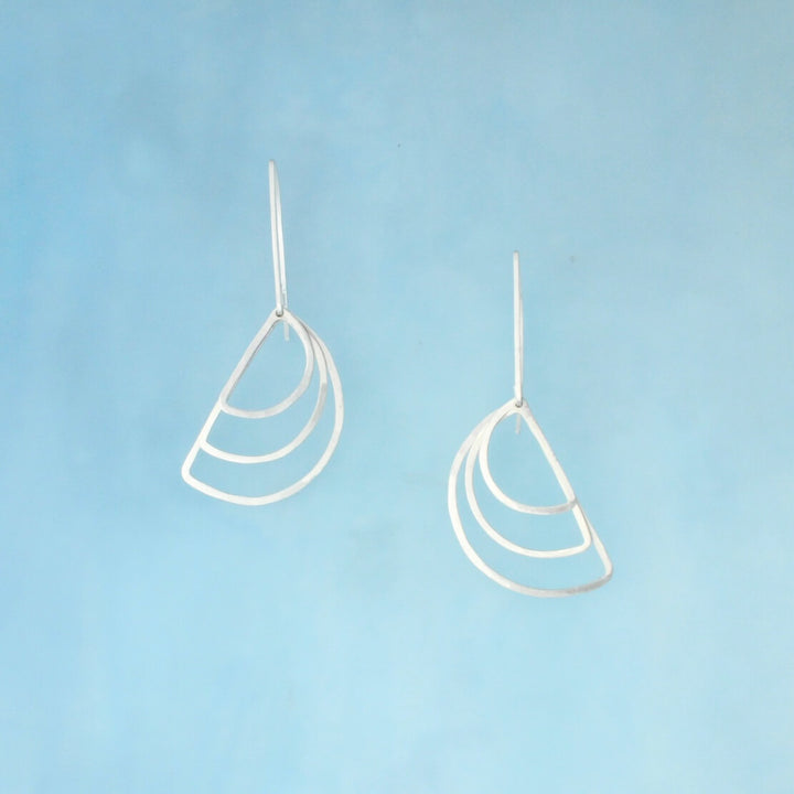 Silver dangle earrings with one inch ear wire holding three layered semicircles